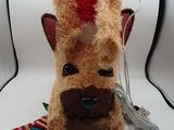 un chien en peluche avec un bonnet rouge et une cravate rayée