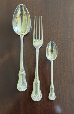 four silver spoons and two silver spoons on a table