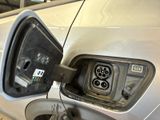 a silver car that has an electric charger attached to it