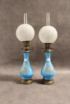 une paire de lampes en verre bleu et blanc posées sur une table