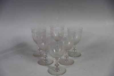 several empty wine glasses are lined up on a white surface