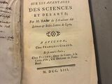 an open book on a table with a piece of paper on top of it