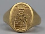an image of a gold signet ring with a coat of arms and a crown on it