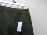 green pants hanging on a hanger in a room with a white wall