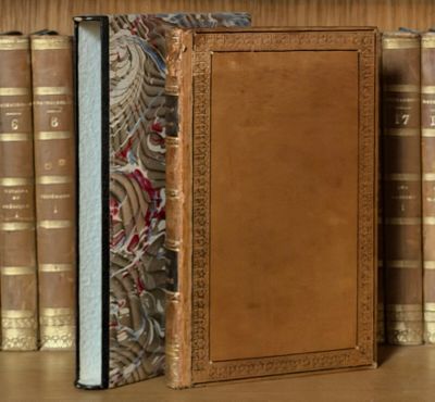 un livre posé sur une étagère, devant une pile de livres