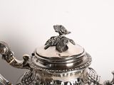 a silver tea pot with a bird on it