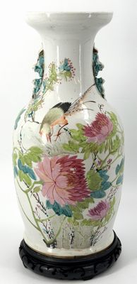 a white vase with a bird and flowers on it