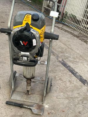 a machine that is sitting on the ground in front of a fence