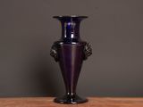a purple vase sitting on top of a wooden table
