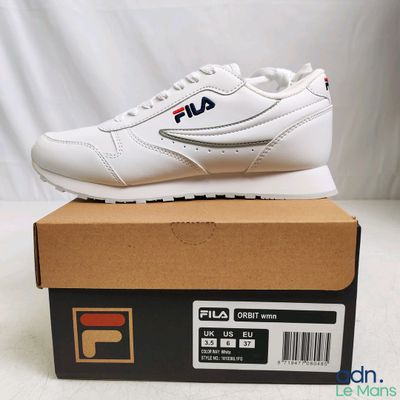 a close up of a pair of white sneakers on a box