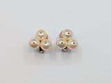 a pair of pearl earrings on a white surface