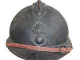 un vieux casque de pompier sur fond blanc, muni d'une lanière en cuir
