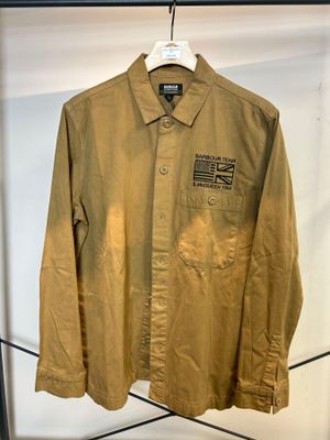 une veste marron suspendue à un portant dans une pièce