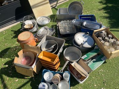plein de casseroles et de poêles posées sur l'herbe