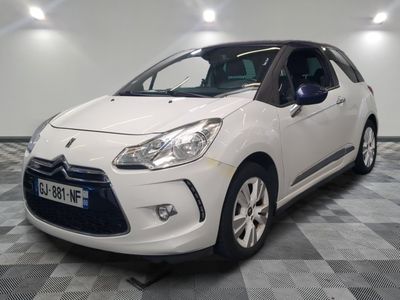 the small white car is parked on a checkered floor