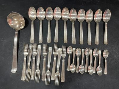many spoons and forks laid out on the table