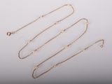 a group of gold necklaces and bracelets on a white surface