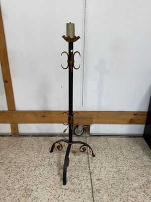 lampadaire en fer forgé muni d'un bougeoir, posé sur un sol en marbre