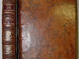 an old book sitting on top of a table next to a closed book