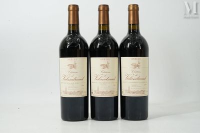 trois bouteilles de vin posées sur une table blanche
