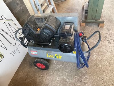 un petit compresseur d'air posé sur un chariot dans le garage