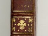 a brown and gold book on a white surface