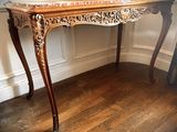 a wooden table with a marble top on a hard wood floor