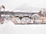 a silver trumpet sitting on a white surface