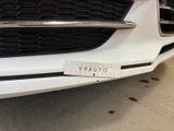 a close up of a white car with a sticker on it