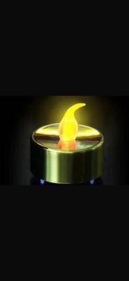une bougie allumée dont la flamme jaune brille dans l'obscurité
