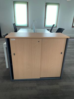 a desk with two chairs and a cabinet in the middle of the room