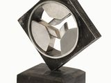 a metal sculpture that is on a wooden base