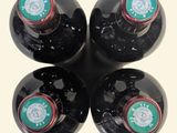 four bottles of wine are lined up in a row on a table
