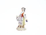 une figurine représentant une femme tenant un panier de fleurs
