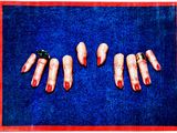 une photo d'une photo montrant les mains d'une femme aux ongles rouges