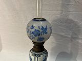 un vase bleu et blanc posé sur un socle, sur une surface blanche