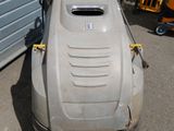 an image of a lawn mower parked in front of a garage