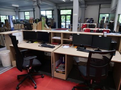 il y a de nombreux ordinateurs sur les bureaux de cette salle