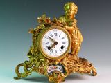 une horloge en or surmontée d'une statue
