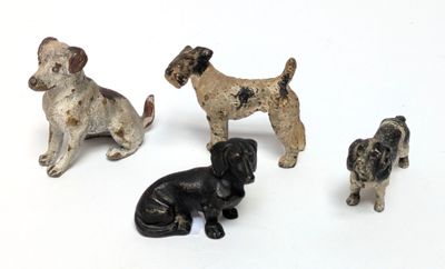 four figurines of dogs sitting on a white surface