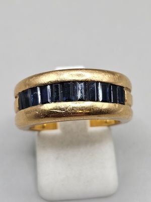 a close up of a gold ring with blue sapphires