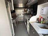 a long narrow kitchen with stainless steel appliances and counters