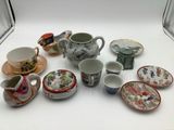 many different types of tea cups and saucers on the table