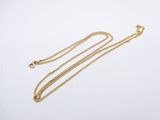 un collier en or avec une longue chaîne sur fond blanc