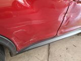 a red car that has a dent in the side of it