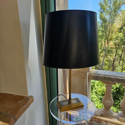 une table en verre sur laquelle est posée une lampe, devant une fenêtre