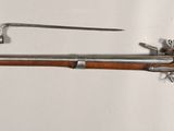 an old rifle with a wooden barrel and a metal handle