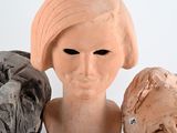 three clay heads of a woman and a man