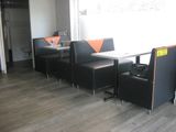 tables and chairs in a restaurant with a large window in the background