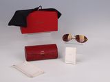 pair of sunglasses and a red case sitting on a white surface